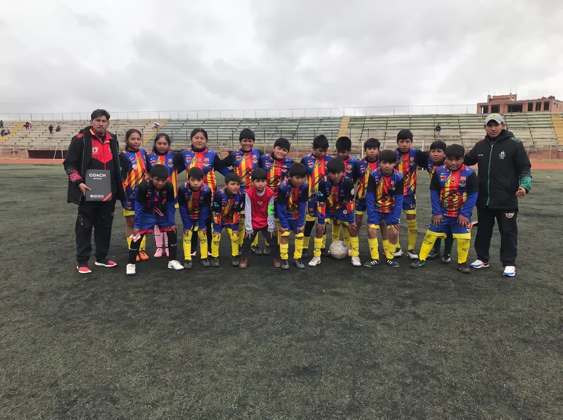 Equipo de Nuevas Estrellas con su entrenador en la cancha