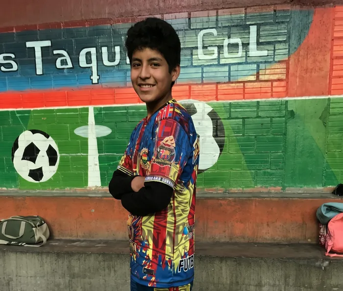 Jugador de Nuevas Estrellas junto al mural de Zas Taquito Gol